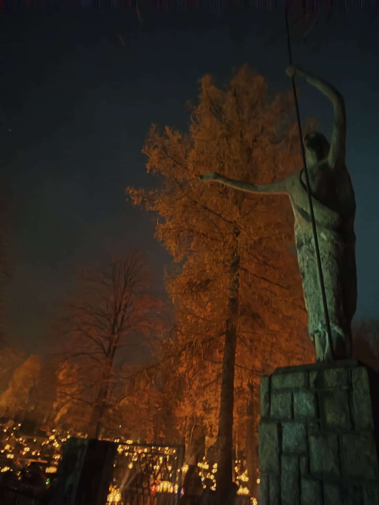 Figura Chrystusa Zmartwychwstałego przy wejściu na cmentarz w Tymbarku w noc Wszystkich Świętych